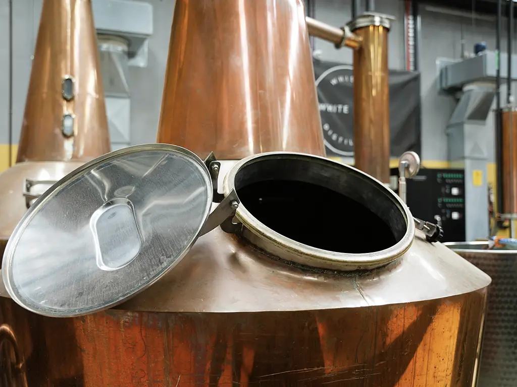 close up of the custom made copper pot still at the white label distillery in tasmania